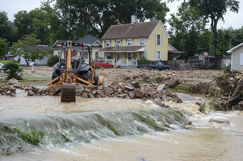 Marion County Public Works crews work to remove rocks and mud that piled up at the intersection of Pine and Third Streets after the July 11 flash flood that inundated portions of South Pittsburg.