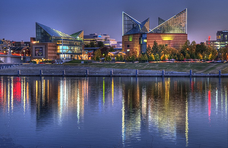 The lights of the Tennessee Aquarium and downtown Chattanooga reflect in the Tennessee River at dusk.