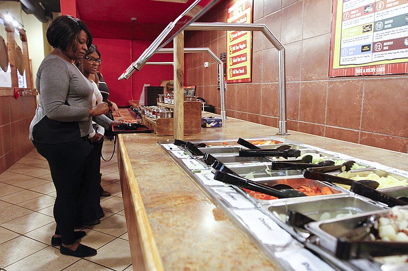Felicia Jackson and her two daughters, Carlicia Woodruff and Briana Brown, wait to place their order at downtown Chattanooga's Genghis Grill.
