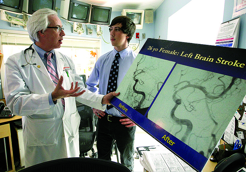 Dr. Tom Devlin, left, and his son Christian, right, talk about a device Christian devised and patented that is designed to act as a bypass system and provide oxygen to brain tissue after clot removal procedures. Christian, a junior at McCallie School, came up with the idea several years ago while watching a clot removal procedure.