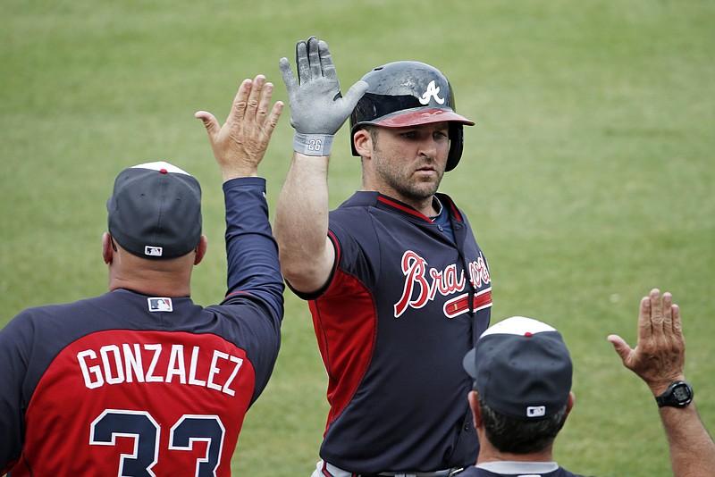 Atlanta Braves manager Fredi Gonzalez, left, congratulates Dan Uggla, center, after Uggla hit a two-run homer off Philadelphia Phillies starting pitcher Mario Hollands in a spring exhibition baseball game in Clearwater, Fla.