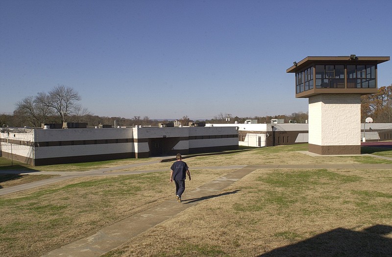 In this file photograph from 2000, an inmate walks across the yard inside the razor-wire fence at the CCA Silverdale Correctional Facility on Standifer Gap Road.