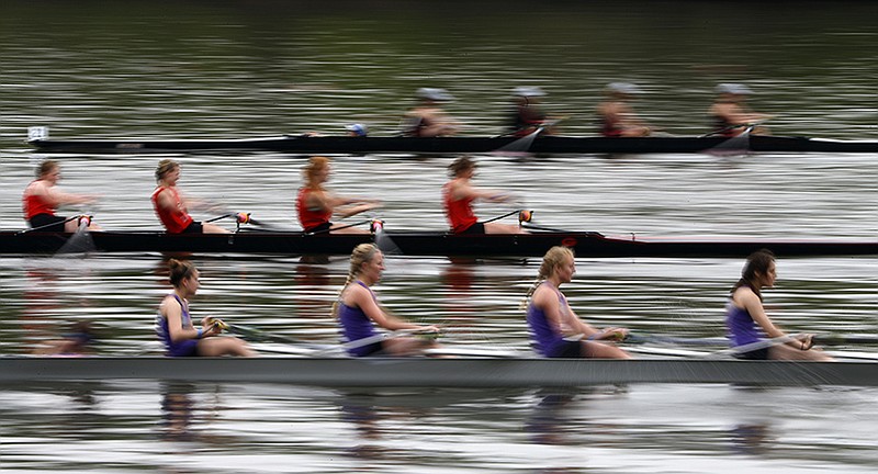 In this photo taken with a slow shutter speed, women's freshmen/novice crew teams from the University of St. Thomas, bottom to top, Georgia University and Colgate University compete in the Dad Vail Regatta on the Schuylkill River, Friday, May 9, 2014, in Philadelphia.