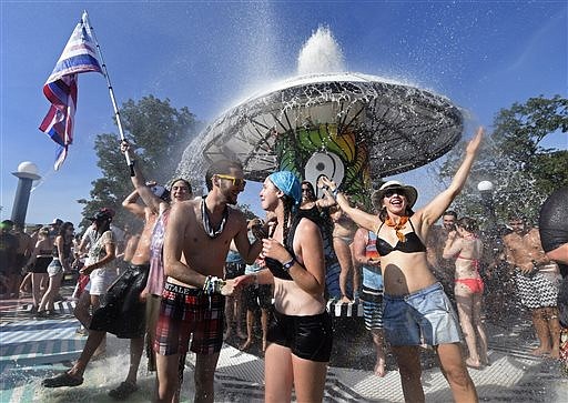Revelers shower beneath the Fountain during the Bonnaroo Music & Arts Festival on Saturday, June 14, 2014, in Manchester, Tenn.