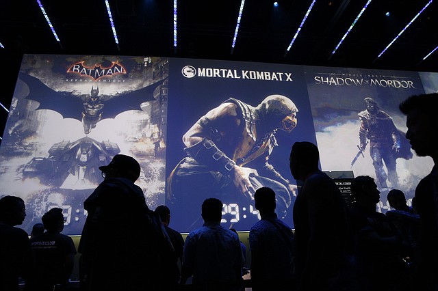 
              FILE - In this Wednesday, June 11, 2014 file photo, people wait in line for theater presentations for video games including Batman, Mortal Kombat X and Shadow of Mordor at the WB Games booth at the Electronic Entertainment Expo, in Los Angeles. At last week's E3, video game developers hyped upcoming titles featuring assassins, super-soldiers, vigilantes and demon hunters. The lack of female protagonists at the expo highlighted an ongoing issue that continues to haunt the video game industry.  (AP Photo/Jae C. Hong, file)
            