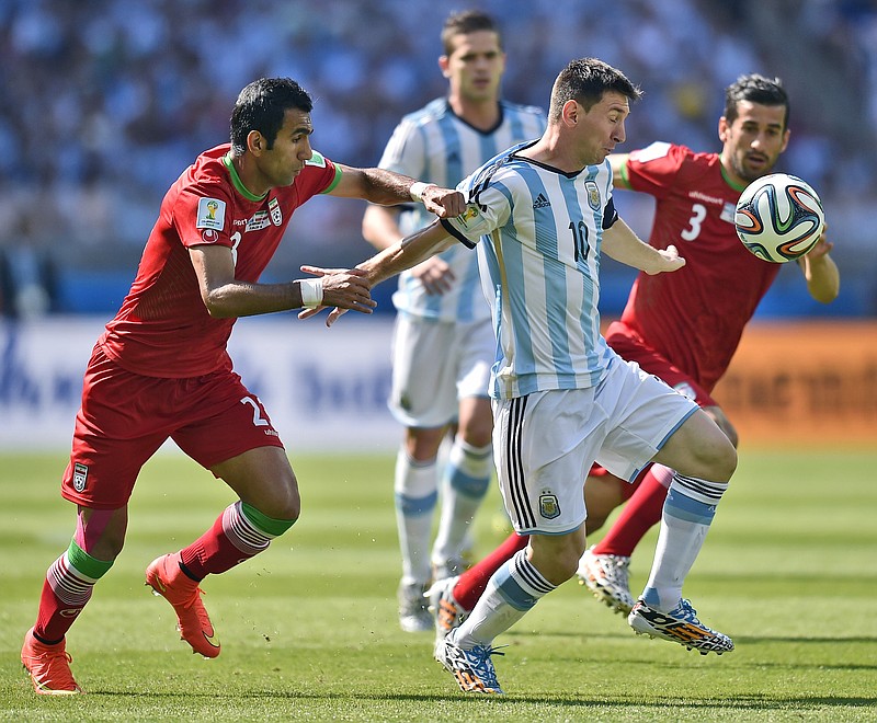 
              Iran's Mehrdad Pooladi, left, holds Argentina's Lionel Messi during the group F World Cup soccer match between Argentina and Iran at the Mineirao Stadium in Belo Horizonte, Brazil, Saturday, June 21, 2014. (AP Photo/Martin Meissner)
            