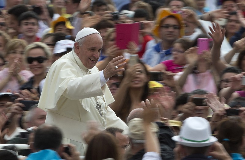 
              Pope Francis waves as he is driven through the crowd during his weekly general audience in St. Peter's Square at the Vatican, Wednesday, June 25, 2014. (AP Photo/Alessandra Tarantino)
            