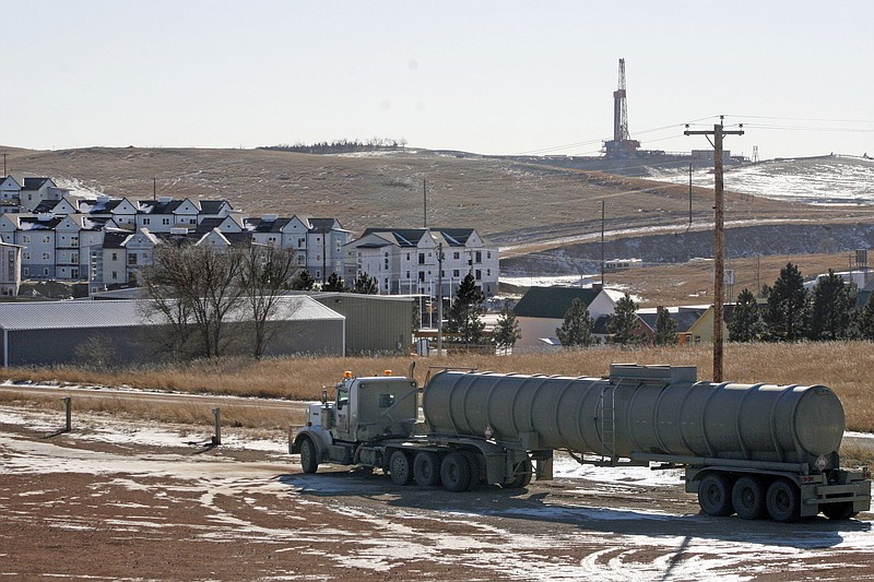 
              FILE - In this Feb. 26, 2014, file photo, an oil truck sits in a dirt lot near a new housing development in Watford City, N.D. The United States is still growing older, but the trend is reversing in the Great Plains, thanks to a liberal application of oil.  (AP Photo/Martha Irvine)
            