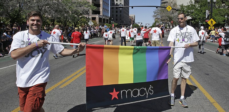 
              In this June 8, 2014, photo, workers carry a Macy's banner during the gay pride parade, in Salt Lake City. Corporations have increased visibility this summer at gay pride parades around the country as same-sex marriage bans fall in the courts and polls show greater public acceptance of gay marriage. (AP Photo/Rick Bowmer)
            