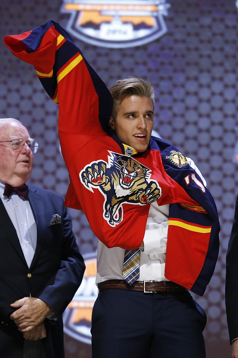 
              Aaron Ekblad pulls on Florida Panthers sweater after being chosen first overall during the NHL hockey draft, Friday, June 27, 2014, in Philadelphia. (AP Photo/Matt Slocum)
            