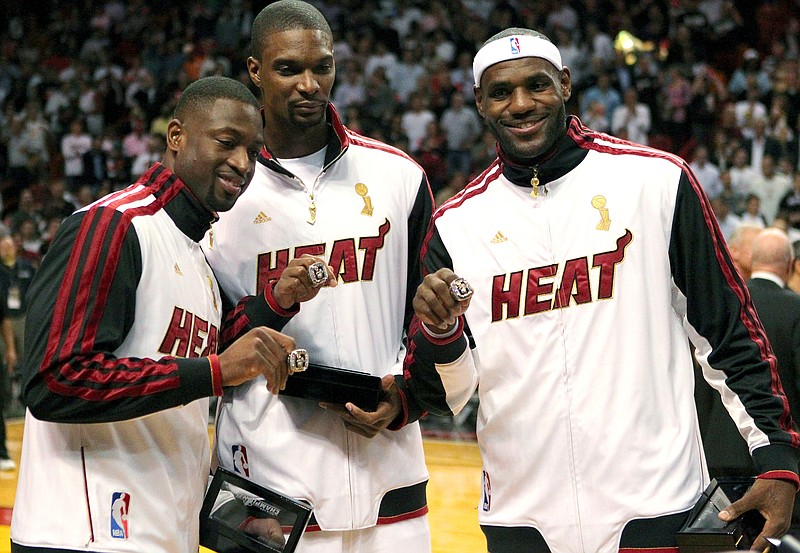
              FILE - In this Oct. 30, 2012 file photo, Miami Heat's Dwyane Wade, left, Chris Bosh, center, and LeBron James pose with their championship rings during a ceremony before an NBA basketball game against the Boston Celtics in Miami. A person familiar with the situation tells The Associated Press that James has decided to opt out of the final two years of his contract with the Heat and become a free agent on July 1. Opting out does not mean James has decided to leave the Heat, said the person, who spoke on condition of anonymity because neither the four-time NBA MVP nor the team had made any public announcement. (AP Photo/El Nuevo Herald, David Santiago, File) MAGS OUT
            