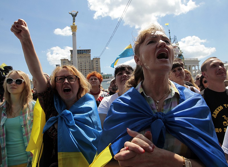 
              People shout slogans during a rally in Independence Square in Kiev, Ukraine, Sunday, June 29, 2014. Hundreds of people have come on Sunday morning to the presidential administration to demand a stop to the cease fire on the eastern part of Ukraine. According to soldiers of the Donbass battalion, the other side hasn't stopped attacks and around 20 soldiers were killed during the last week that suppose to be a pause in active fighting. (AP Photo/Sergei Chuzavkov)
            