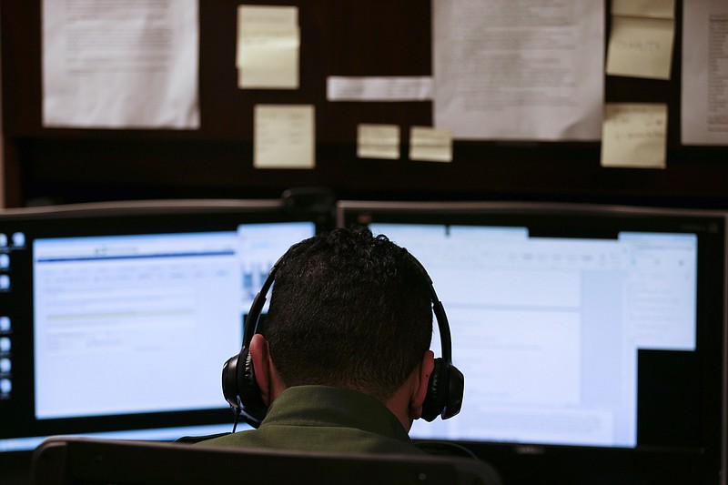 
              In this June 5, 2014 photo, a Border Patrol agent uses a headset and computer to conduct a long distance interview by video with a person arrested crossing the border in Texas, from a facility in San Diego. Hit with a dramatic increase of Central Americans crossing in South Texas, the Border Patrol is relieving staffing woes by enlisting agents in less busy sectors to process arrests through video interviews.  (AP Photo/Gregory Bull)
            