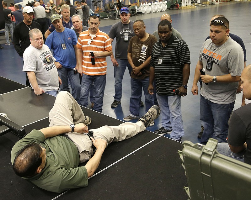 
              In this June 3, 2014 photo, Houston police officers learn learn how to apply a tourniquet to a leg at the police academy in Houston. Cities across the country are training and equipping police officers to use tourniquets and combat gauze. (AP Photo/Pat Sullivan)
            
