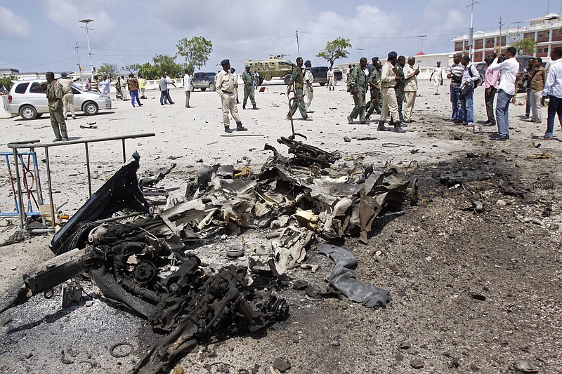 
              Somali soldiers stand near the wreckage of a suicide car bomb near the Somali parliament in Mogadishu, Somalia, Saturday, July 5, 2014. A Somali police officer says troops have thwarted an attack by a suicide bomber outside the heavily guarded parliament headquarters. Capt. Mohamed Hussein, a senior Somali police officer says troops stopped a suicide car bomber who detonated his explosive-laden car at a checkpoint near the entrance to Somalia's parliament. (AP Photo/Farah Abdi Warsameh)
            