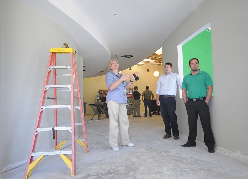 Ivy Academy Executive Director Angie Markum, left,  talks about the conceptual design of the entry hallway reflecting the school's environmental mission. Architect Matthew Parks, right, and area specialist for the USDA Rural Development Program Clay Copeland listen to the explanation.