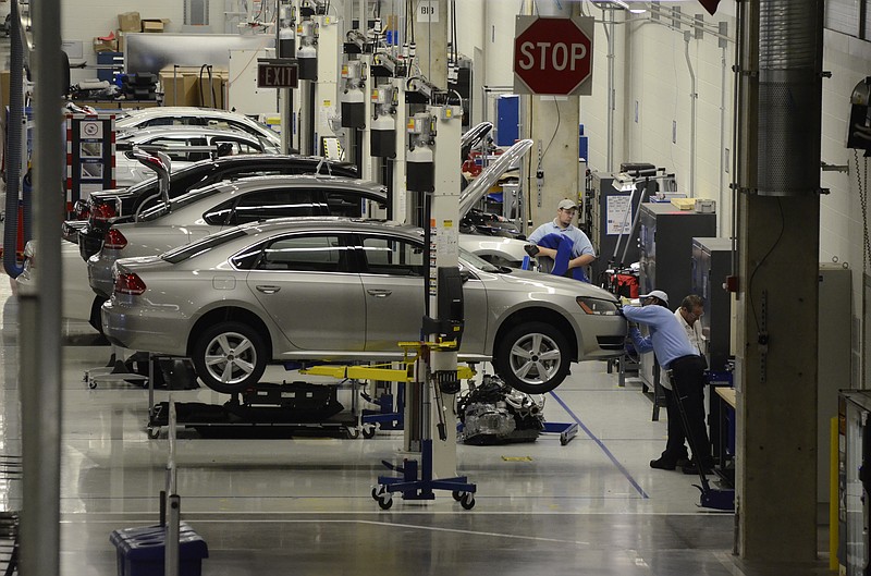 Volkswagen workers and Passats are seen at the Chattanooga manufacturing plant .