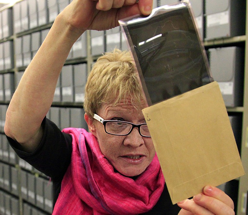 
              FILE - This, Feb. 23, 2012, file photo shows Bridget Sisk, chief of Archives and Records Management Section (ARMS) at the United Nations, as she views a 1947 negative file during a special tour of U.N. historical archives. A largely unknown archive documenting thousands of cases against World War II criminals, from Hitler to many average participants in the Holocaust who were never brought to trial, are being made public and unrestricted for the first time at the U.S. Holocaust Memorial Museum in Washington after being locked away for decades at the United Nations. (AP Photo/Bebeto Matthews, File)
            
