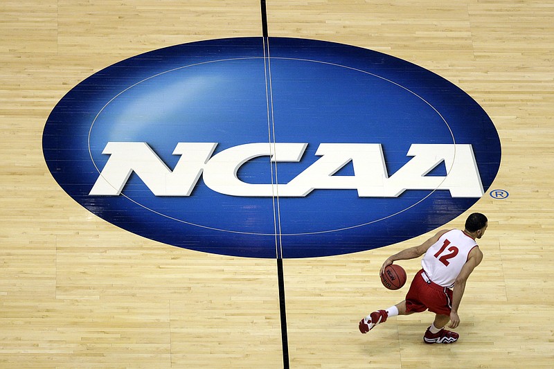 
              FILE - In this March 26, 2014, file photo, Wisconsin's Traevon Jackson dribbles past the NCAA logo during practice at the NCAA men's college basketball tournament in Anaheim, Calif. A federal judge ruled that the NCAA can't stop players from selling the rights to their names, images and likenesses, striking down NCAA regulations that prohibit them from getting anything other than scholarships and the cost of attendance at schools. U.S. District Judge Claudia Wilken in Oakland, Calif., ruled in favor Friday, Aug. 8, of former UCLA basketball star Ed O'Bannon and 19 others in a lawsuit that challenged the NCAA's regulation of college athletics on antitrust grounds. (AP Photo/Jae C. Hong, File)
            