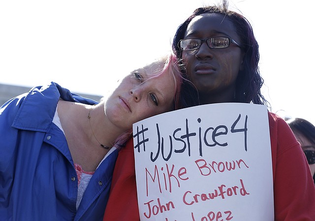 
              Savannah McCoy, 17, right, holds up a sign as she and her friend Kimber Camgros, 16, listen to speakers during a vigil for Michael Brown of Ferguson, Mo., in San Francisco, Thursday, Aug. 14, 2014. Brown, an unarmed black teenager, was killed by a white police officer on Saturday, Aug. 9, 2014. (AP Photo/Jeff Chiu)
            