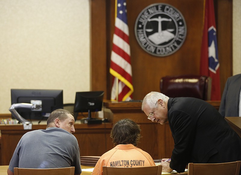 Defense attorney Martin Levitt, right, talks with defendant Jacob Allison, center, during a hearing Friday, Aug. 22, 2014, in juvenile court in Chattanooga, Tenn., to determine whether Allison, a 16-year-old juvenile who is charged along with two adult men in an April triple-homicide in Lookout Valley, should be transferred to adult court. Judge Rob Philyaw ruled that Allison would be charged as an adult with 3 counts of murder and 1 count of attempted murder.