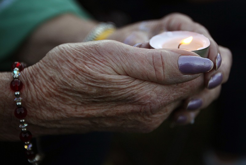 
              A woman holds a candle during a vigil for James Foley in his hometown of Rochester, N.H., Saturday, Aug. 23, 2014. Several hundred people attended and paid tribute to the freelance American journalist who was killed earlier in the week by Islamic State militants. Foley was abducted in November 2012 while covering fighting in Syria. (AP Photo/Jim Cole)
            
