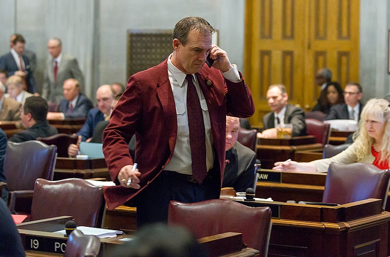 Rep. Rick Womick, R-Murfreesboro, speaks on his cellphone during a House floor session In Nashville on Feb. 20, 2014.