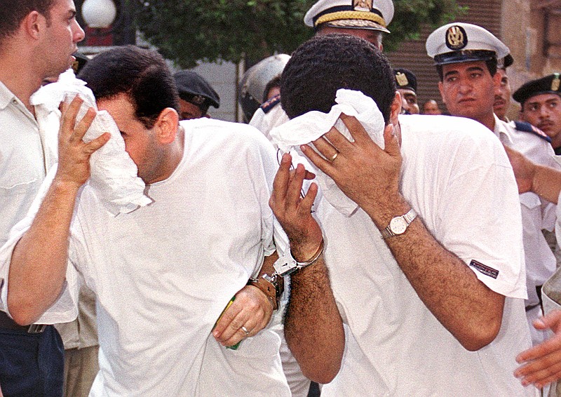 
              FILE - In this Wednesday, July 18, 2001 file photo, two of 52 men accused of breaking laws covering obscenity and public morality cover their faces as they enter a state security court for their trial, in Cairo, Egypt. On Saturday, Sept. 6, 2014, Egypt's top prosecutor has ordered seven men detained and physically examined over accusations of "debauchery," a charge often leveled at gays, after a video emerged of a same-sex wedding party. In a statement Saturday, the prosecutor said the suspects are also accused of broadcasting footage that "violates public decency," ordering them detained for four days pending an investigation.  (AP Photo/ File)
            