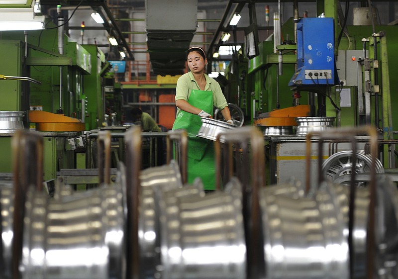 
              In this Thursday, Aug. 21, 2014 photo, a woman works at a factory manufacture aluminum wheel hubs in Zouping county in east China's Shandong province. Chinese premier Li Keqiang promised Wednesday, Sept. 10, 2014 to open its economy wider to foreign businesses, promising favorable conditions amid a wave of anti-monopoly investigations that business groups say might be aimed at limiting competition. (AP Photo) CHINA OUT
            