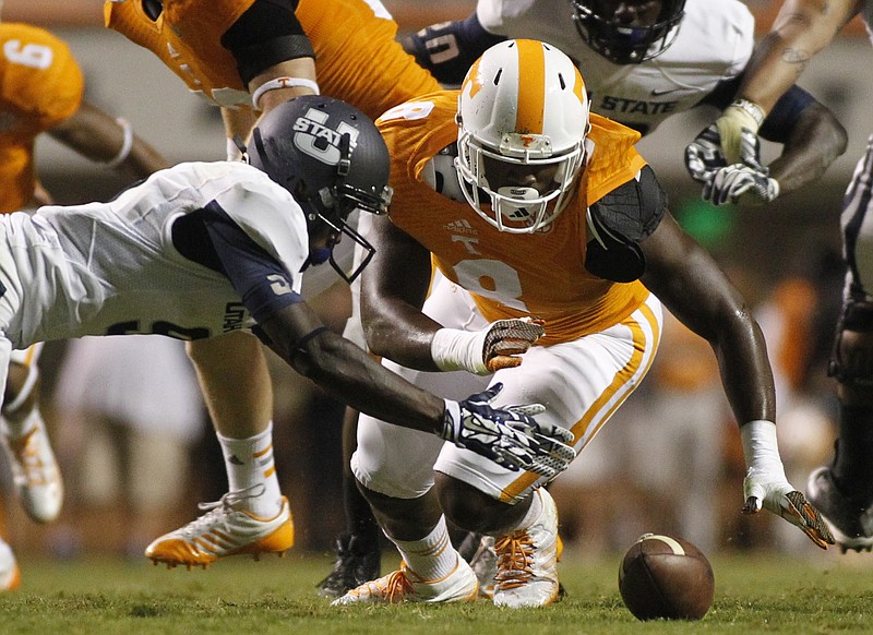 Tennessee defensive lineman Dewayne Hendrix, right, and Utah State wide receiver Kyler Fackrell fall onto a ball after it was fumbled by Fackrell.