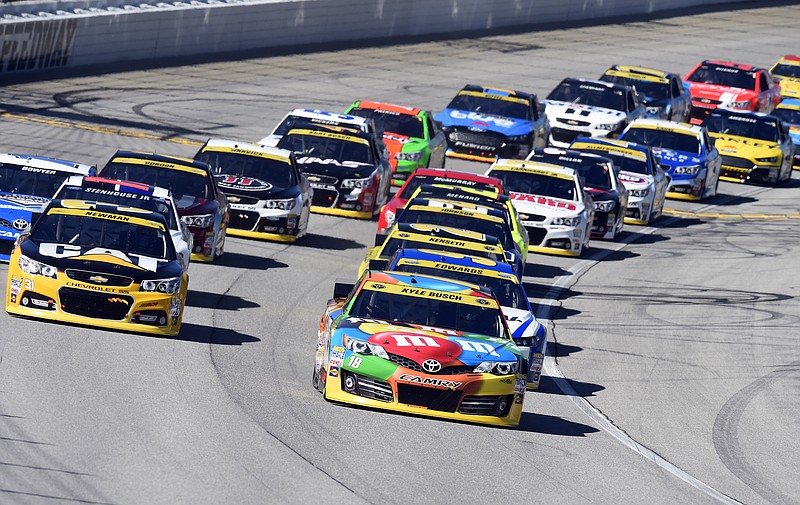 
              Kyle Busch (18) leads the field at the start of the NASCAR Sprint Cup series auto race at Chicagoland Speedway in Joliet, Ill., Sunday, Sept. 14, 2014. (AP Photo/Paul J. Bergstrom)
            