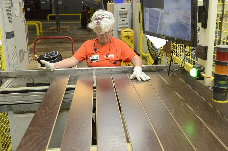 Deborah Blount visually inspects finished flooring slats at the Shaw Industries hardwood flooring plant in South Pittsburg, Tenn.