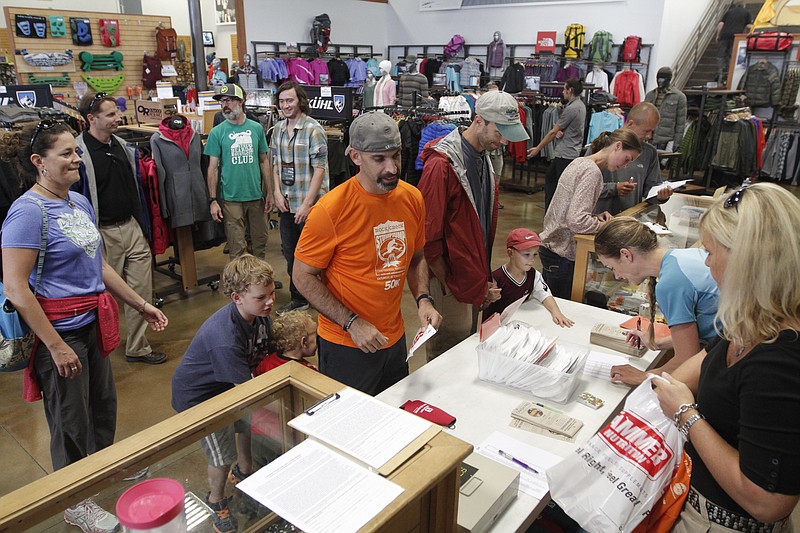 Racers pick up their bibs and registration bags for the Rock/Creek StumpJump on Friday at Rock/Creek Outfitters in Chattanooga. Hundreds of runners are competing in the Rock/Creek StumpJump, which consists of either an 11 mile or a 50 kilometer trail race on Saturday.