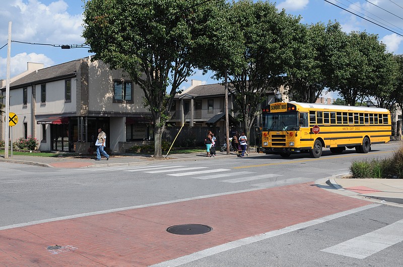 Elementary age children exit a Hamilton County school bus in front of the Family Housing and Learning Center last in the 700 block of East 11th Street.