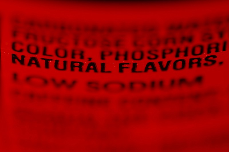 Label shows the ingredients on a bottle of Coca-Cola. "Artificial and natural flavors" have become ubiquitous terms on food labels, helping create vivid tastes that would otherwise be lost in mass production. As the science behind them advances, however, some are calling for greater transparency about their safety and ingredients.