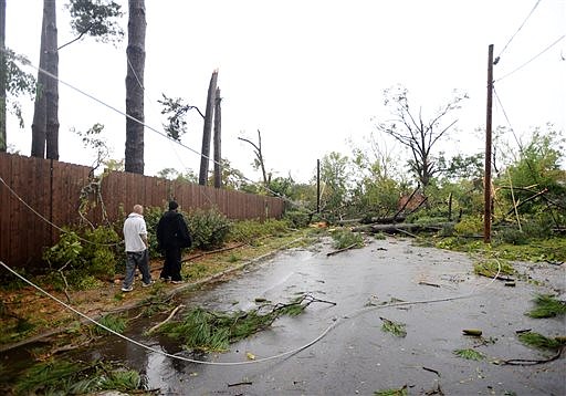 John Puriet, left, and Mike Doyle walk down a street in the Garden District to check on Doyle's mother-in-laws house that was damaged in the storm, Monday, Oct. 13, 2014 in Monroe, La. (AP Photo/The Times, Henrietta Wildsmith)