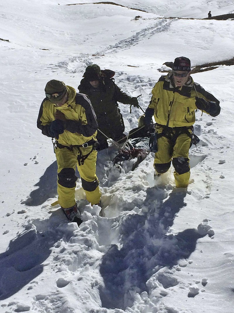 
              In this photo released by the Nepalese Army, rescue team members carry a victim of an avalanche before they airlift the body from Thorong La pass area, in Nepal, Thursday, Oct. 16, 2014. Search teams in army helicopters rescued dozens of stranded foreign trekkers and recovered more bodies of victims of a blizzard and avalanches in the mountains of northern Nepal on Thursday. (AP Photo/The Nepalese Army)
            