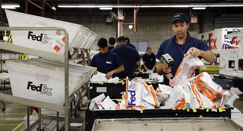 
              In this July 9, 2014 photo, David Demeter sorts packages at the FedEx Express station in Nashville, Tenn. FedEx on Wednesday, Oct. 22, 2014 forecast that deliveries between Thanksgiving and Christmas Eve will rise 8.8 percent over last year, to 290 million shipments. That's a more subdued forecast than a year ago, when FedEx predicted 13 percent growth for the season. (AP Photo/Mark Humphrey)
            