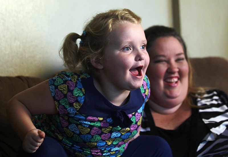 
              FILE - In this Monday, Sept. 10, 2012, file photo, beauty pageant regular and reality show star Alana "Honey Boo Boo" Thompson speaks during an interview as her mother, June Shannon, looks on in her home in McIntyre, Ga. On Friday, Oct. 24, 2014, the TLC network canceled the “Here Comes Honey Boo Boo” series, following published reports that Shannon was in a relationship with a man who had a criminal past. (AP Photo/John Bazemore, File)
            