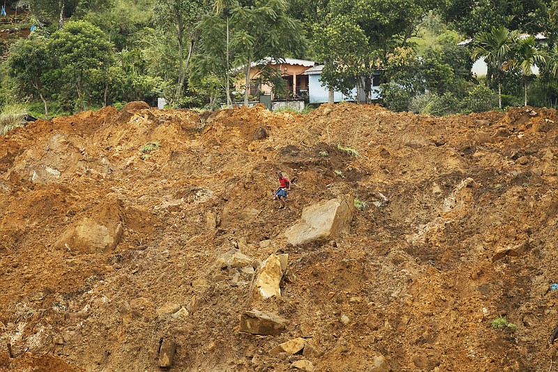 
              A Sri Lankan navigates his way though mud and sludge caused by a mudslide at the Koslanda tea plantation in Badulla district, about 220 kilometers (140 miles) east of Colombo, Thursday, Oct. 30, 2014. Disaster Management Minister Mahinda Amaraweera estimated the number of dead in Wednesday's disaster at the plantation would be fewer than 100, although villagers said the figure could easily exceed 200. (AP Photo/Eranga Jayawardena)
            