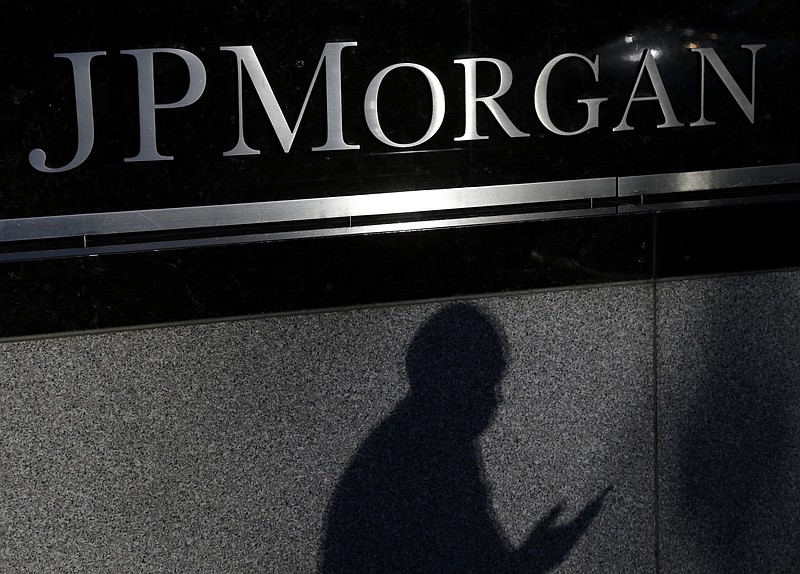 
              FILE - In this Nov. 19, 2013, file photo, the shadows of a pedestrian is cast under a sign in front of JPMorgan Chase & Co. headquarters in New York. JPMorgan Chase on Monday, Nov. 3, 2014 said the Justice Department has opened a criminal investigation into its foreign exchange business. (AP Photo/Seth Wenig, File)
            