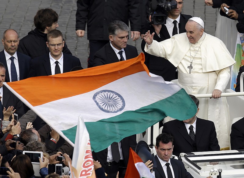 
              An Indian flag is waved near Pope Francis at the end of the Canonization mass for Eufrasia Eluvathingal, Amato Ronconi, Antonio Farina, Kuriakose Elias Chavara, Nicola Saggio da Longobardi and  Ludovico da Casoria, in St. Peter's Square, at the Vatican, Sunday, Nov. 23, 2014. Pope Francis has canonized six new saints, including a priest and a nun from the Indian state of Kerala, in a packed ceremony in St. Peter's Square. The Pope offered prayers Sunday for the saints, four Italians from disparate regions and two Indians from the Syro-Malabar Church, one of 22 Eastern rite churches that operates in full communion with Rome. Some 5,000 faithful traveled from Kerala state for the event, which was also streamed live onto screens set up outside churches in the southern region of India. (AP Photo/Gregorio Borgia)
            