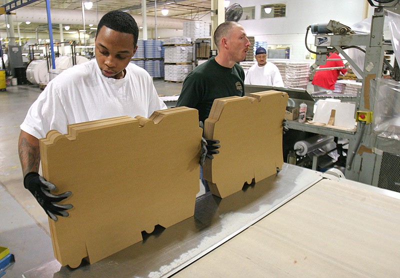 Southern Champion Tray employees work at the company's North Chattanooga plant, where they straighten boxes and maintain equipment, as shown in this file photo.