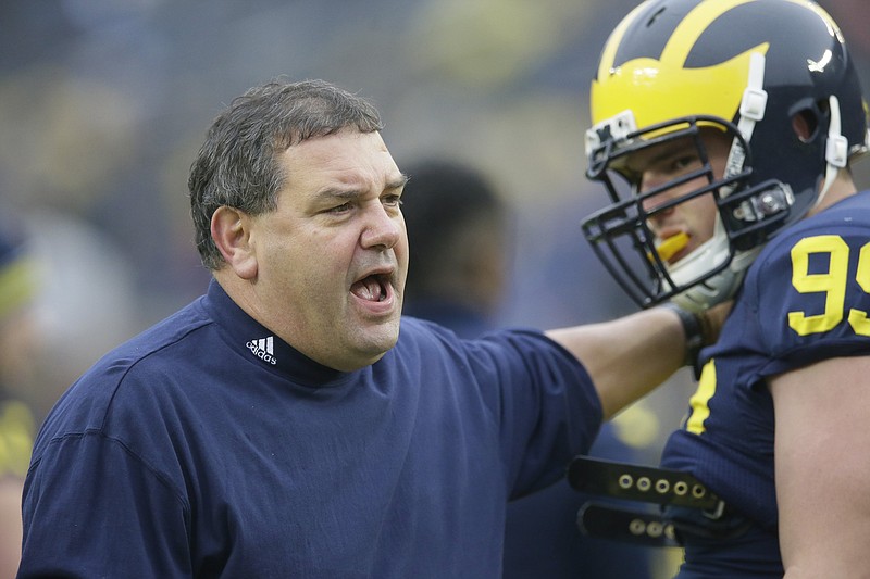 
              FILE - In this Nov. 22, 2014, file photo, Michigan head coach Brady Hoke, left, talks with defensive tackle Matthew Godin during warm ups before an NCAA college football game against Maryland in Ann Arbor, Mich. While keeping track on rivalries and games with playoff implication, there are a few coaching hot spots to keep an eye on this weekend. Another loss will put Michigan out of the postseason and make it three straight seasons of declining win totals under Hoke. (AP Photo/Carlos Osorio, File)
            