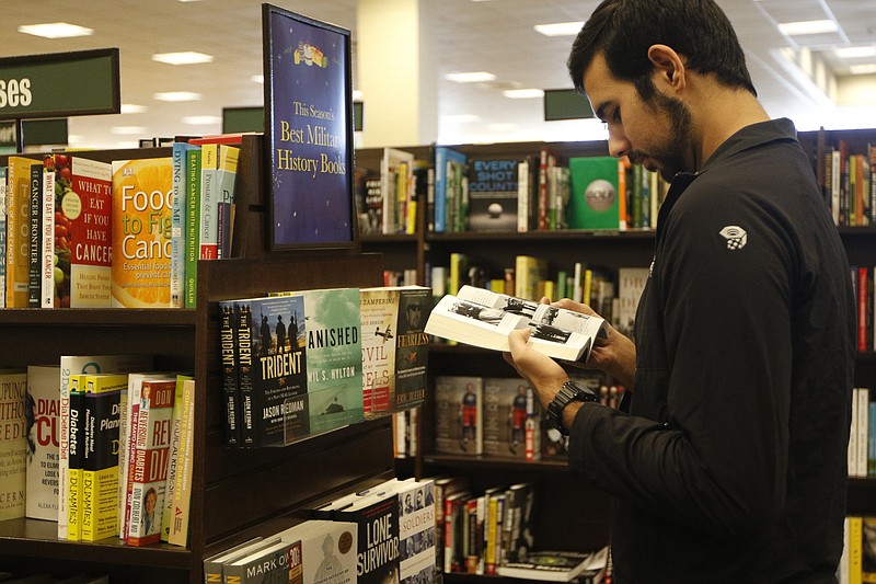 Prescott Khair looks at a book for sale at Barnes and Noble.