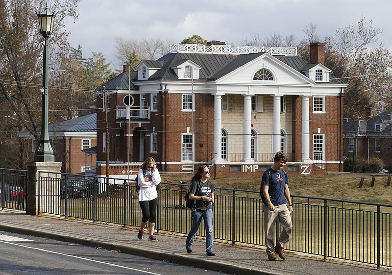 University of Virginia students walk to campus past the Phi Kappa Psi fraternity house at the University of Virginia in Charlottesville, Va., in this Nov. 24, 2014, file photo.