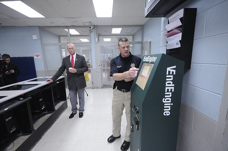Hamilton County Sheriff Jim Hammond, left, and Deputy Chief Joe Fowler introduce the new commissary kiosk system in one of the booking areas at the Hamilton County Jail.