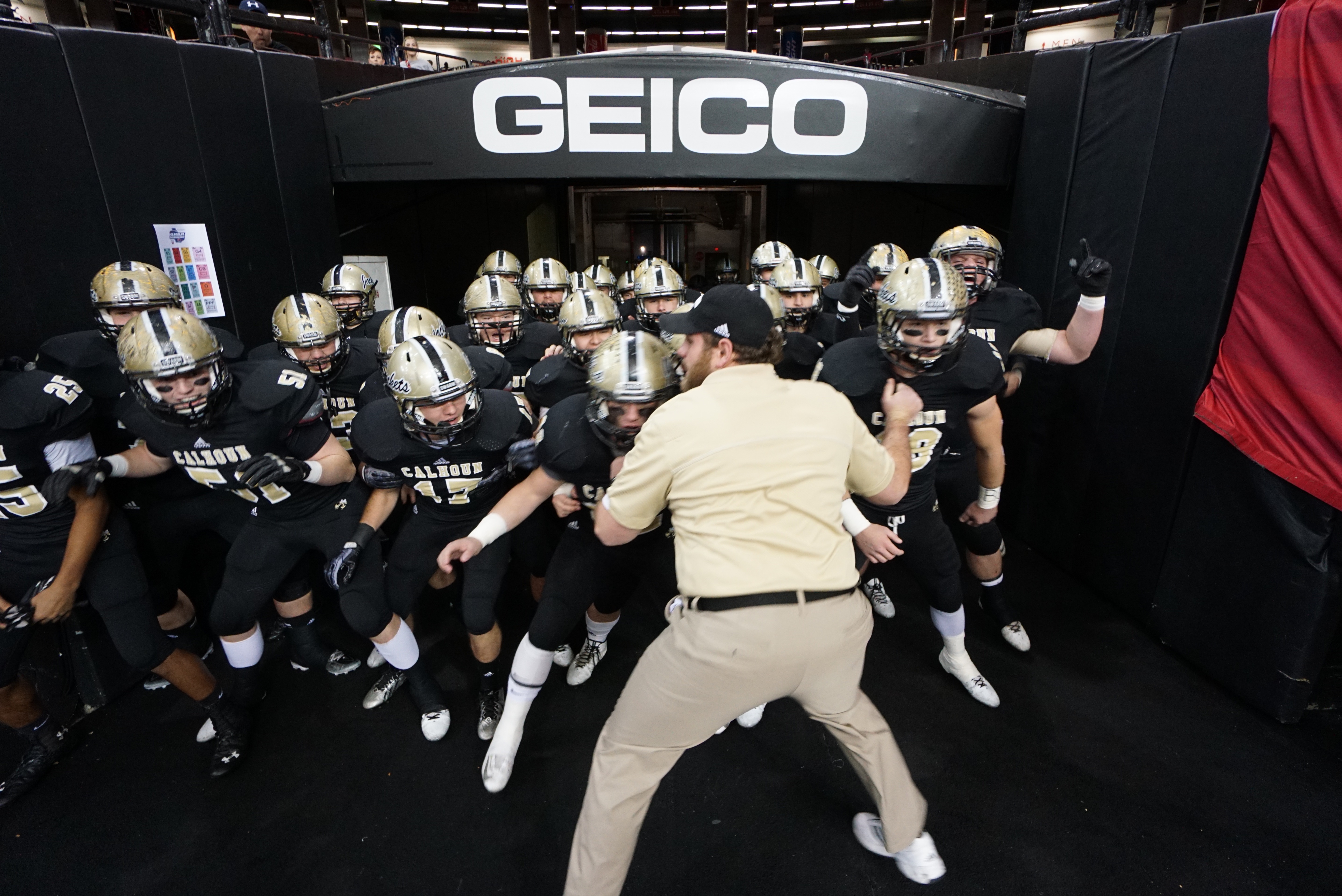 Calhoun High School offensive line coach Sam Robison rials up the team as they prepare to take the field to warm up before playing Washington County in the GHSA class AAA championship game at the Georgia Dome in Atlanta on Friday, December 12, 2014.
