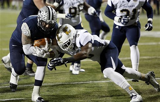 New Hampshire's Nico Steriti drives past Chattanooga's Nakevion Lesloie to score in their NCAA FCS college football quarterfinals Friday, Dec. 12, 2014, in Durham, N.H. 