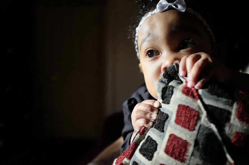 Four-month-old Journee Akins sits on her grandmother Ayesha Pankey's lap on Friday. Journee's mother, Jasmine Akins, was shot to death on Market Street in September, and Pankey and her son Jamaine now are raising Journee.